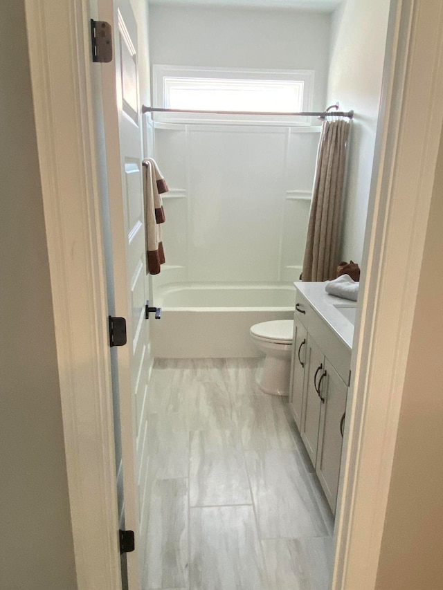 full bathroom with shower / bath combination with curtain, vanity, and toilet