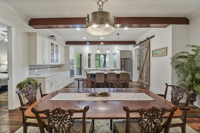 1193 River Rd, Johns Island, SC 29455 - dining room with beam ceiling, a barn door, crown molding, dark wood-style flooring, and baseboards