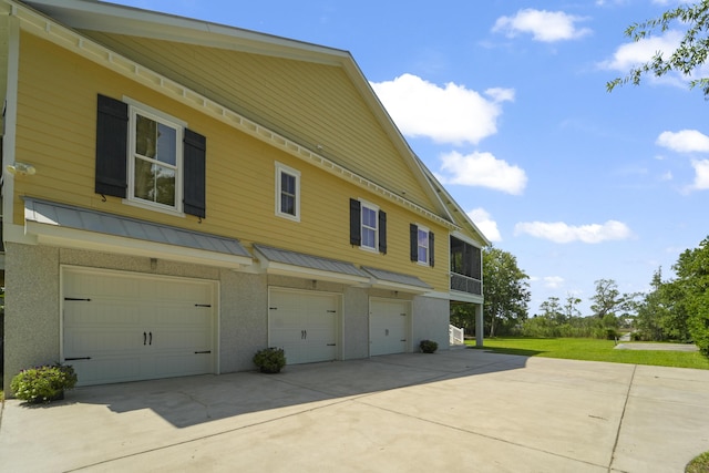 1193 River Rd, Johns Island, SC 29455 - view of property exterior with a garage, driveway, a standing seam roof, metal roof, and stucco siding