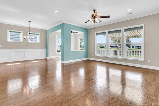 unfurnished living room featuring ceiling fan with notable chandelier, hardwood / wood-style floors, and crown molding