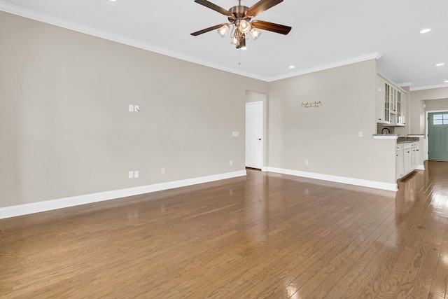 empty room with ceiling fan, ornamental molding, and dark wood-type flooring