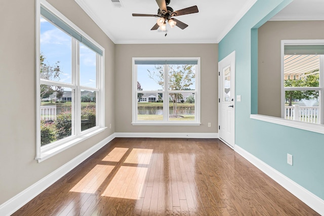 interior space with a water view, ornamental molding, hardwood / wood-style floors, and ceiling fan