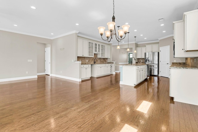 kitchen with hanging light fixtures, white cabinets, hardwood / wood-style flooring, a center island with sink, and stainless steel fridge with ice dispenser