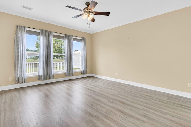 empty room featuring light hardwood / wood-style flooring, ceiling fan, and ornamental molding