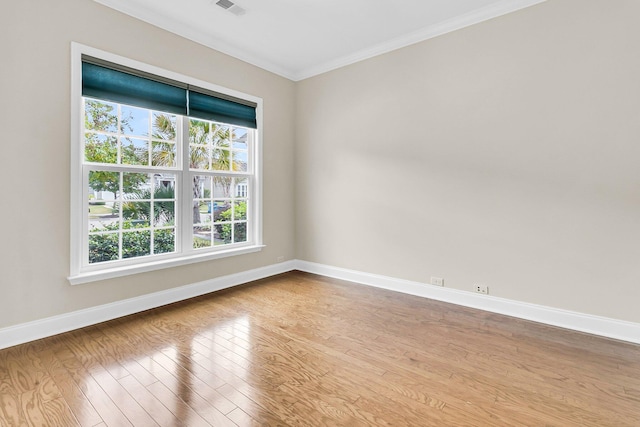 spare room featuring a healthy amount of sunlight, light hardwood / wood-style floors, and crown molding