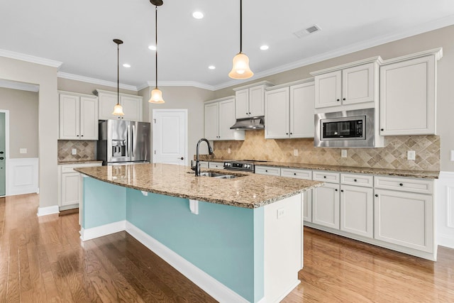 kitchen with a center island with sink, white cabinetry, light hardwood / wood-style flooring, and stainless steel appliances