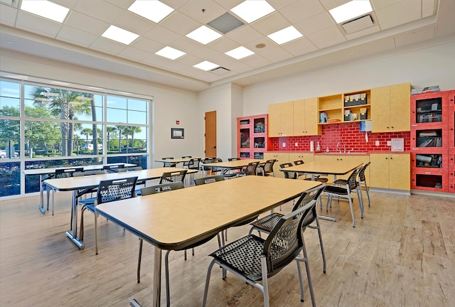 rec room with light hardwood / wood-style flooring, a drop ceiling, and sink