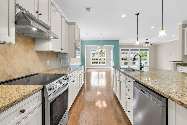 kitchen featuring ceiling fan, pendant lighting, sink, stainless steel appliances, and light hardwood / wood-style floors