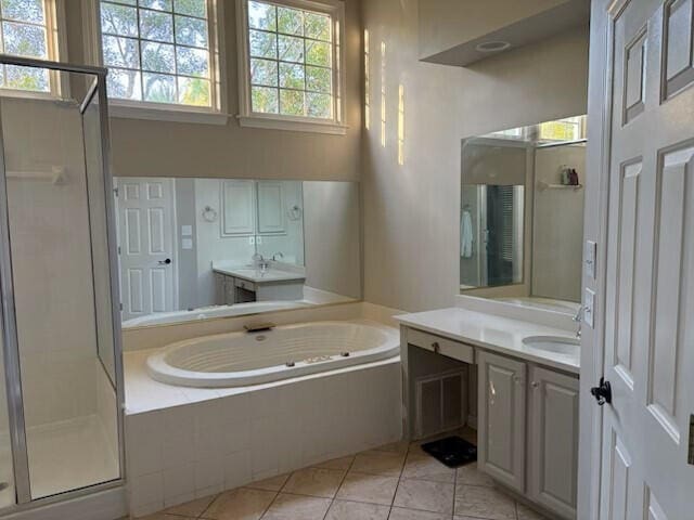 full bathroom with a garden tub, a sink, tile patterned floors, and two vanities