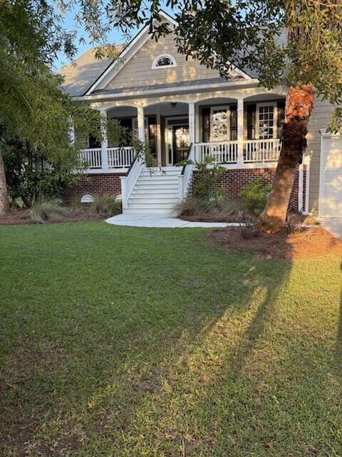 view of front of home with covered porch, a front lawn, and stairway
