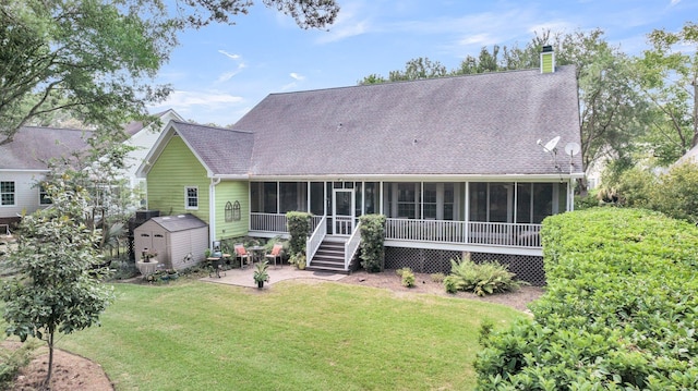 back of property with a sunroom, a yard, a patio, and a shed