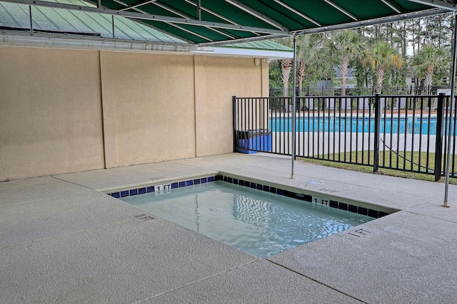 view of swimming pool with an in ground hot tub