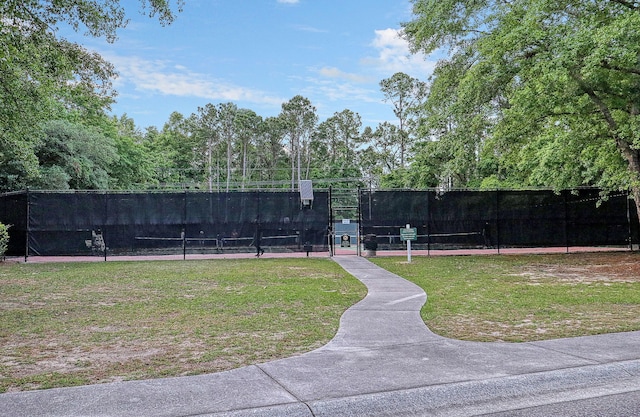 view of property's community with a lawn and tennis court