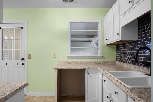 kitchen with white cabinetry, sink, and tasteful backsplash