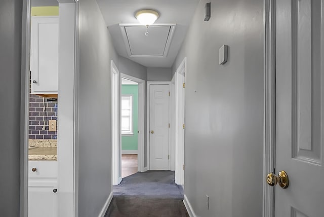 hallway featuring dark carpet