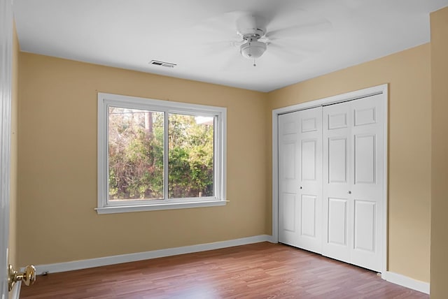 unfurnished bedroom featuring ceiling fan, light hardwood / wood-style floors, and a closet