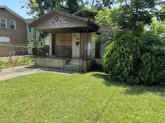 bungalow-style home with covered porch and a front lawn