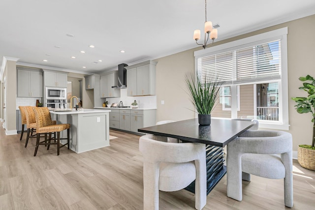 1304 Lieben Rd, Mount Pleasant, SC 29466 - kitchen with appliances with stainless steel finishes, wall chimney exhaust hood, gray cabinetry, a center island with sink, and light wood-style flooring