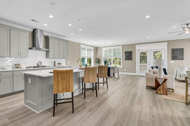 1304 Lieben Rd, Mount Pleasant, SC 29466 - kitchen featuring wall chimney range hood, gray cabinets, french doors, a kitchen island with sink, and recessed lighting