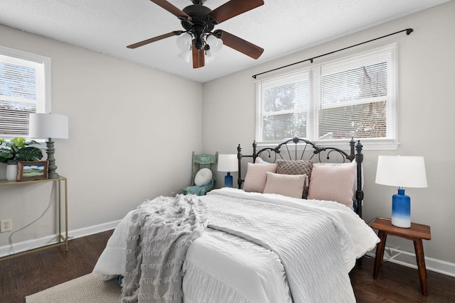 bedroom with a textured ceiling, dark wood-type flooring, and ceiling fan