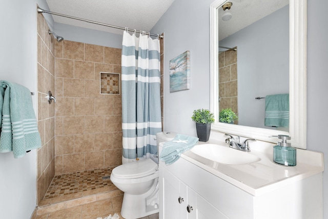 bathroom with a shower with curtain, vanity, a textured ceiling, tile patterned flooring, and toilet