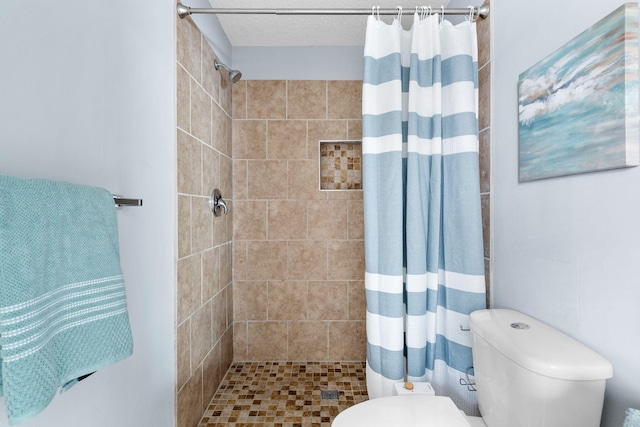 bathroom with a shower with shower curtain and toilet