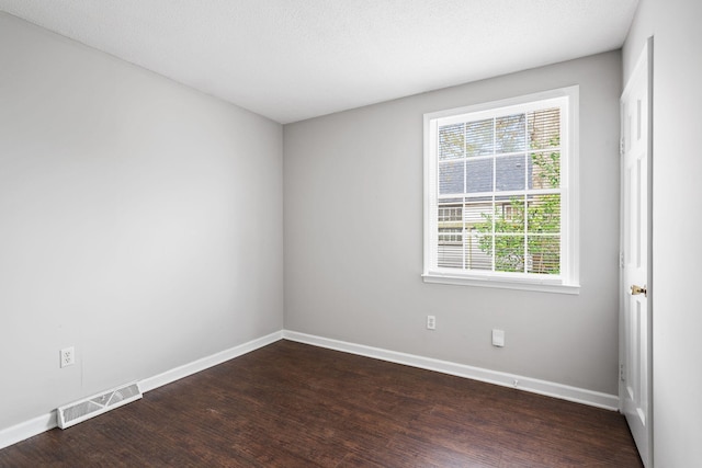 spare room with dark wood-type flooring and a textured ceiling