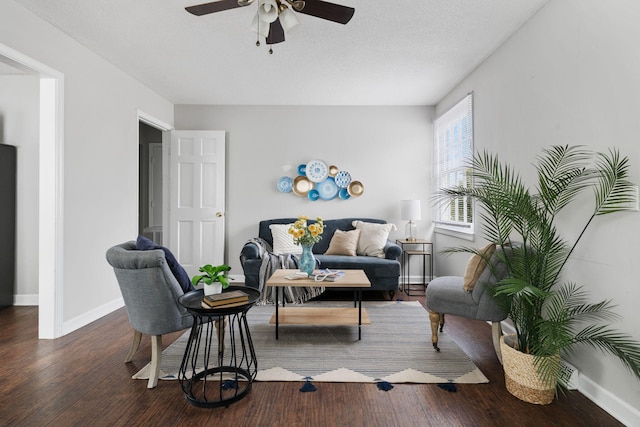 living area with dark hardwood / wood-style flooring, ceiling fan, and a textured ceiling