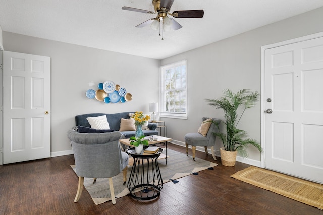 living area featuring ceiling fan and dark hardwood / wood-style flooring