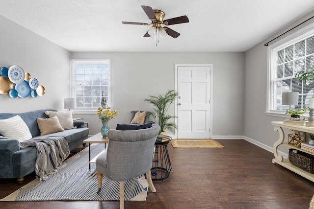 living room featuring ceiling fan, plenty of natural light, dark wood-type flooring, and a textured ceiling