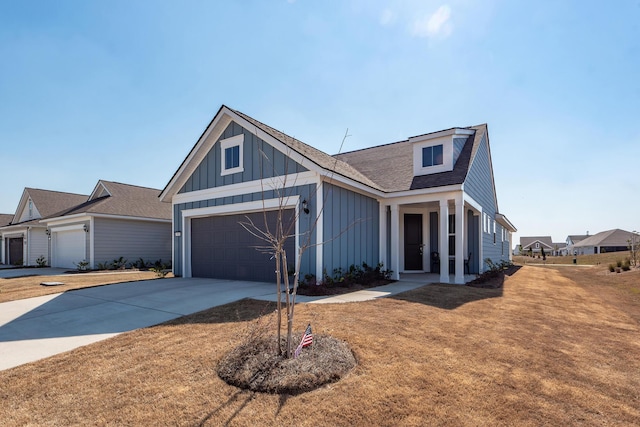 view of front facade featuring a garage, concrete driveway, roof with shingles, a front lawn, and board and batten siding