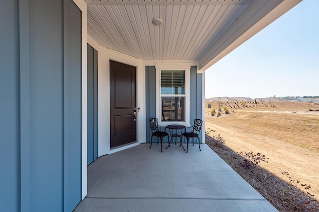 doorway to property with a rural view and a mountain view