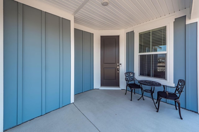 property entrance featuring board and batten siding and covered porch