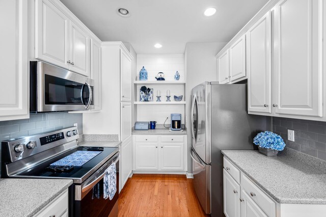 kitchen with white cabinetry, open shelves, recessed lighting, light wood finished floors, and appliances with stainless steel finishes