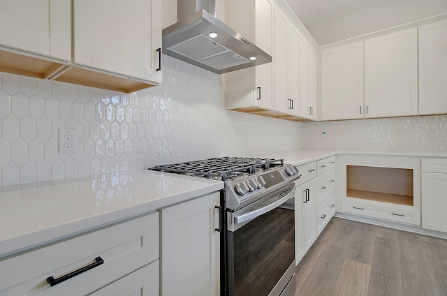 kitchen with stainless steel range with gas cooktop, extractor fan, light wood-type flooring, and decorative backsplash