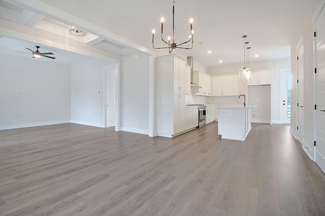 unfurnished living room featuring a ceiling fan, light wood-type flooring, a chandelier, recessed lighting, and baseboards