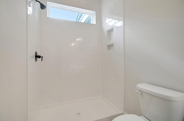 bathroom featuring toilet and tiled shower