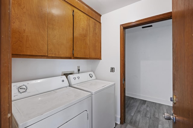 clothes washing area featuring wood-type flooring, cabinets, and independent washer and dryer