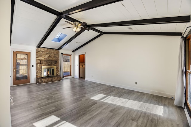 unfurnished living room with a fireplace, hardwood / wood-style floors, vaulted ceiling with skylight, and ceiling fan