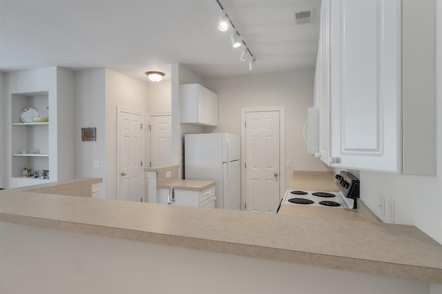 kitchen featuring white cabinets, rail lighting, and white appliances