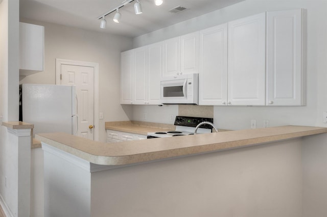 kitchen featuring white appliances, rail lighting, white cabinetry, and kitchen peninsula