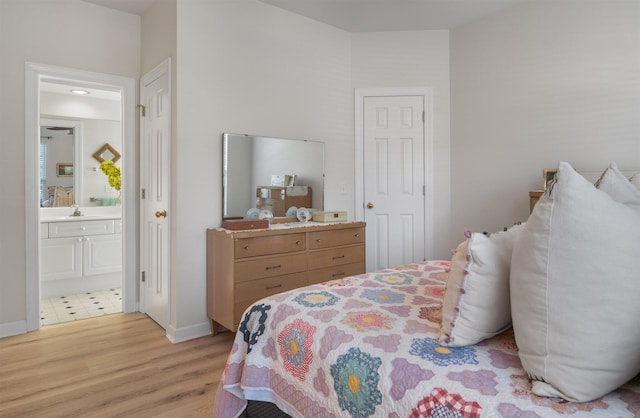 bedroom featuring sink, ensuite bathroom, and light hardwood / wood-style flooring