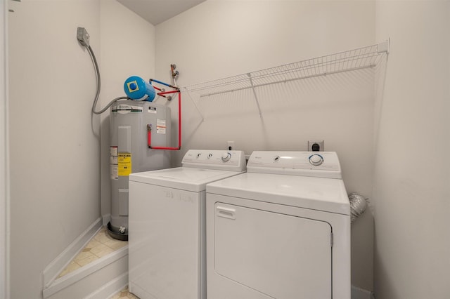 washroom featuring tile patterned floors, water heater, and separate washer and dryer