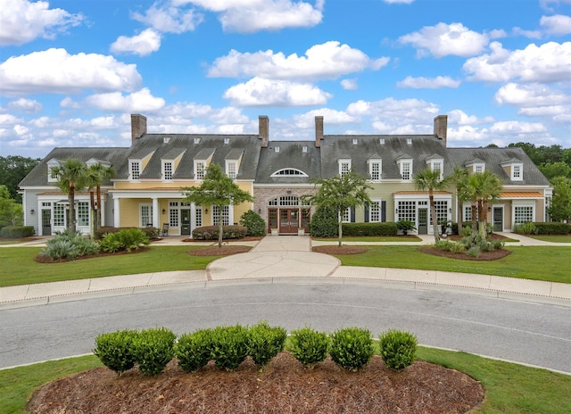 view of front of home with french doors and a front lawn