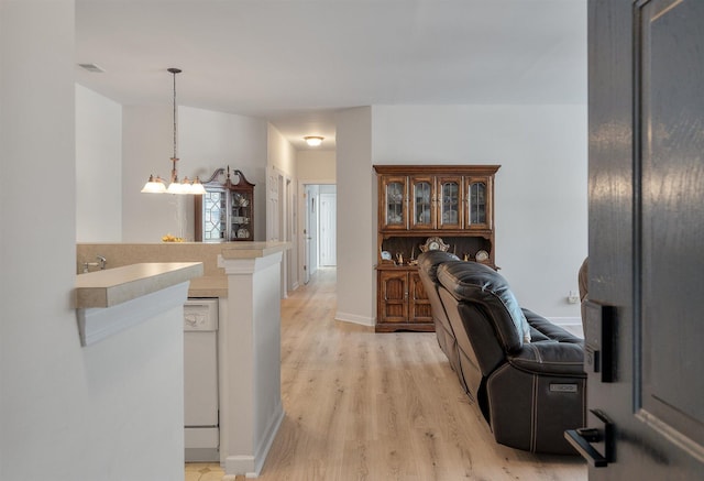 kitchen featuring light hardwood / wood-style flooring, a notable chandelier, and decorative light fixtures