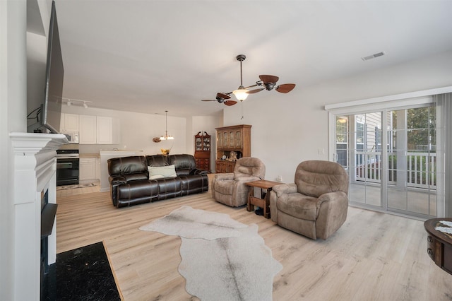 living room featuring light wood-type flooring and ceiling fan