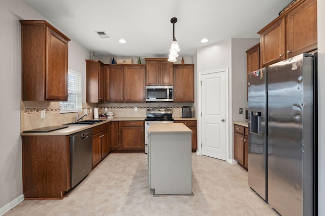 kitchen with a sink, tasteful backsplash, a center island, stainless steel appliances, and light countertops