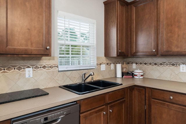 kitchen featuring a sink, tasteful backsplash, dishwasher, and light countertops