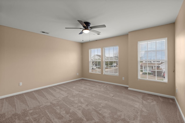 carpeted empty room featuring visible vents, ceiling fan, and baseboards