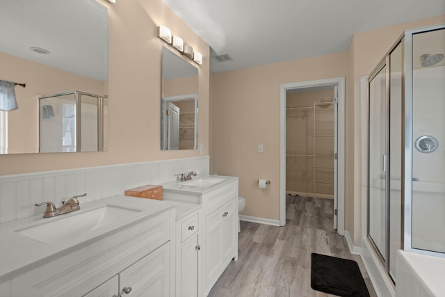 bathroom featuring a sink, a stall shower, and double vanity